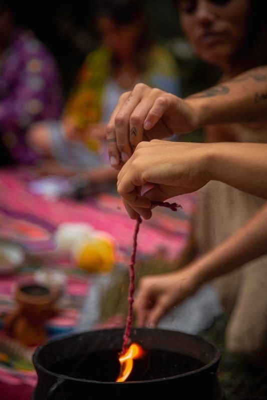 Hand pouring liquid in a fire ceremony