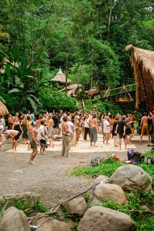People walking through the jungle to a festival venue